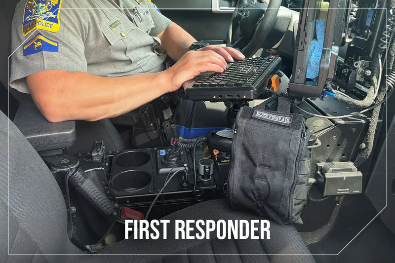 A police officer in uniform typing on a ruggedized laptop mounted in a vehicle.