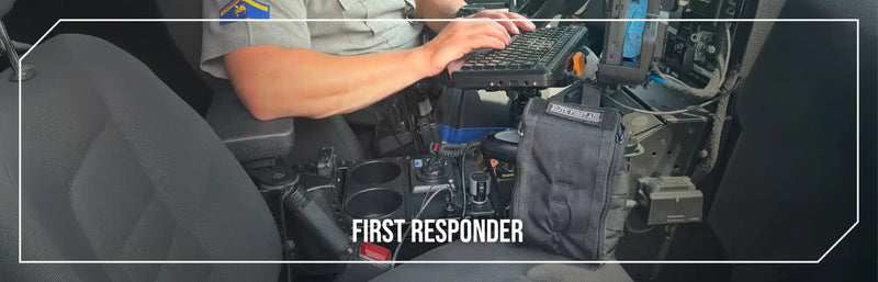 Police officer in a vehicle using a mounted laptop.